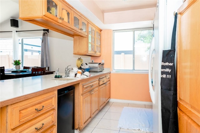 kitchen featuring light tile patterned floors, glass insert cabinets, light countertops, and a sink