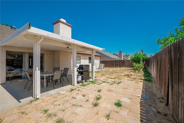 view of patio / terrace featuring area for grilling, cooling unit, outdoor dining area, and a fenced backyard