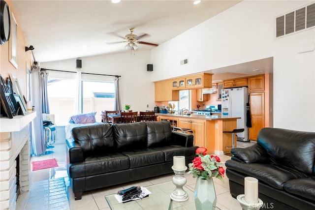 tiled living room featuring ceiling fan, lofted ceiling, and a fireplace