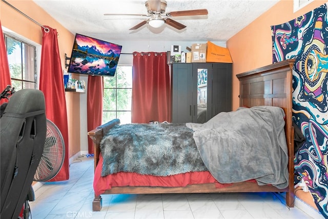 bedroom with a ceiling fan, visible vents, and a textured ceiling