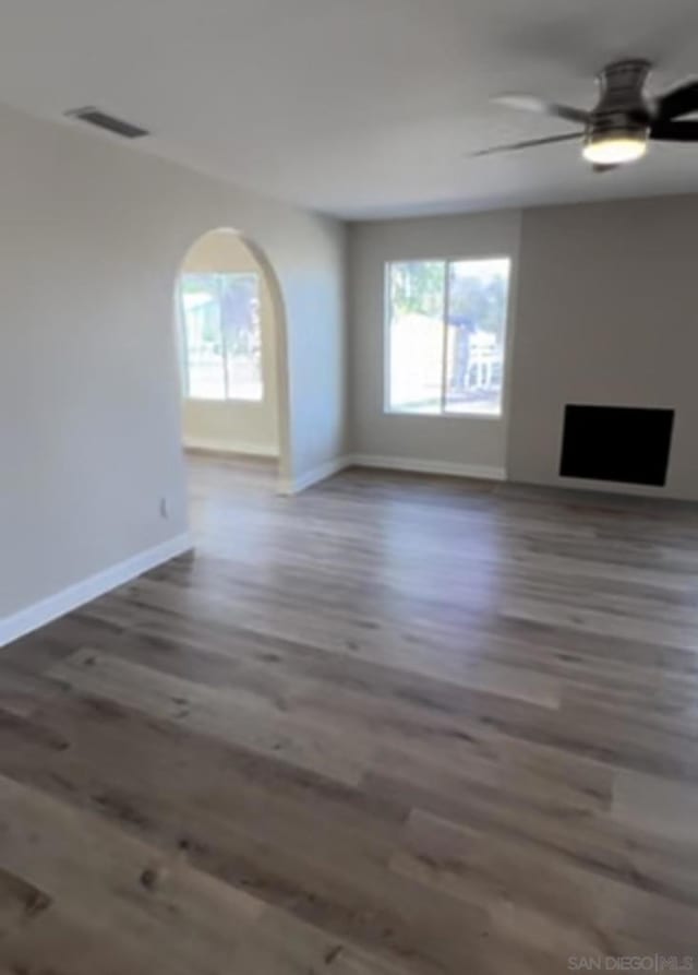 unfurnished living room featuring ceiling fan and dark hardwood / wood-style floors