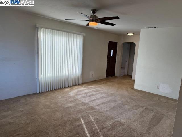 spare room featuring ceiling fan and carpet flooring