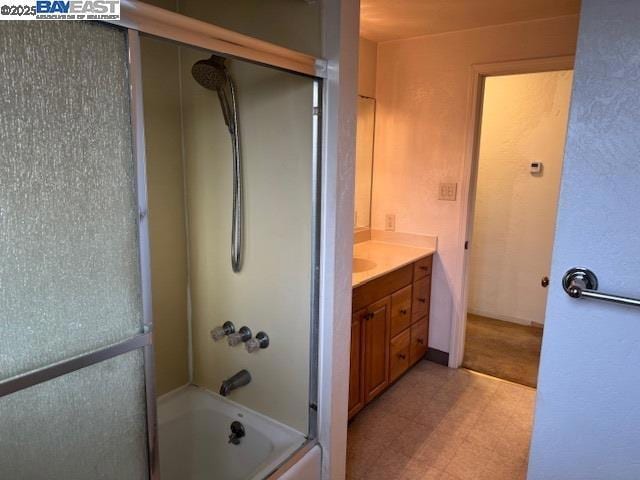 bathroom featuring shower / bath combination with glass door and vanity