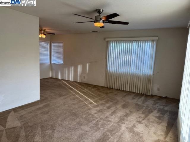 empty room with carpet floors and ceiling fan