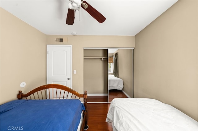 bedroom featuring a closet, visible vents, a ceiling fan, wood finished floors, and baseboards