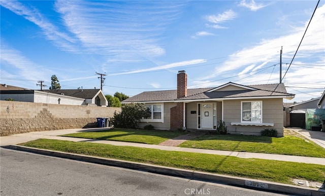 ranch-style house with a front lawn, a chimney, and fence