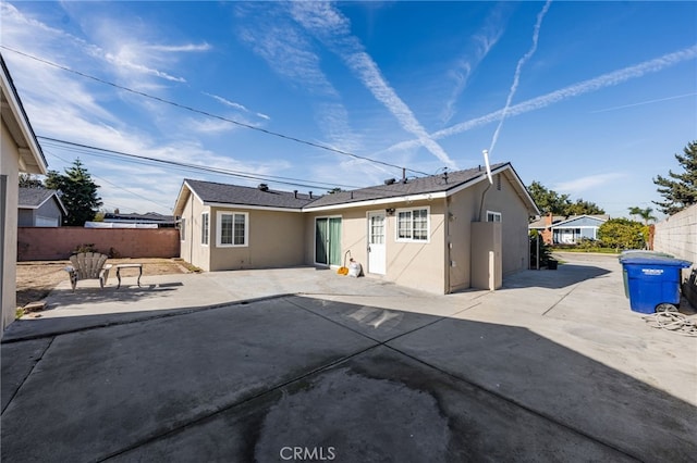 back of property featuring fence, a patio, and stucco siding