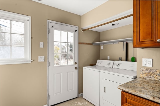 laundry room with cabinet space, washing machine and clothes dryer, and light tile patterned floors