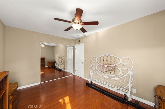 unfurnished bedroom with a closet, wood finished floors, and baseboards