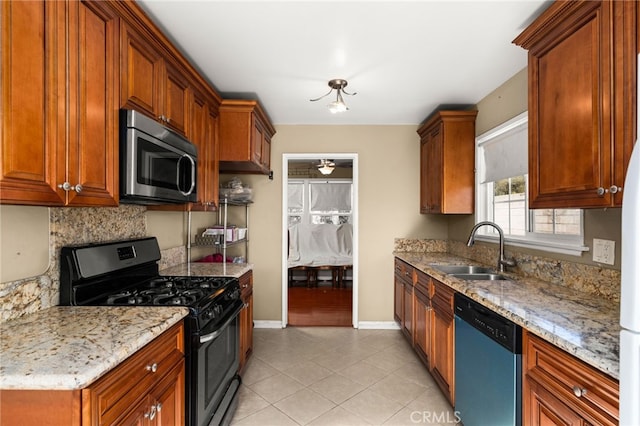 kitchen with decorative backsplash, dishwashing machine, gas range, stainless steel microwave, and a sink