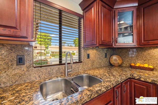 kitchen with sink, stone countertops, and decorative backsplash