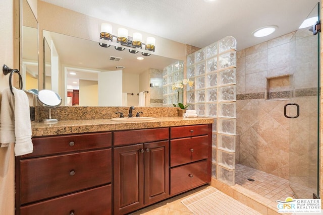 bathroom featuring an enclosed shower, tile patterned floors, and vanity