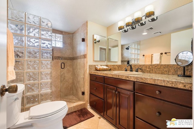 bathroom featuring vanity, toilet, tile patterned floors, and a shower with shower door