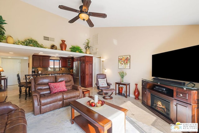 living room with ceiling fan, high vaulted ceiling, and light tile patterned floors