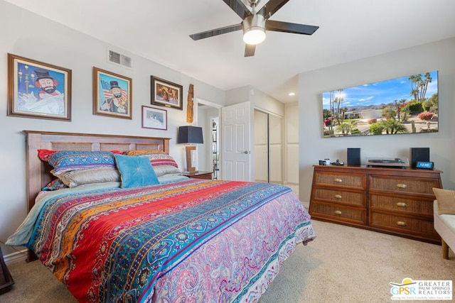 bedroom featuring light colored carpet, a closet, and ceiling fan