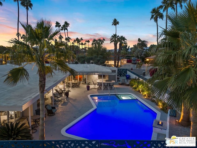 pool at dusk with a patio