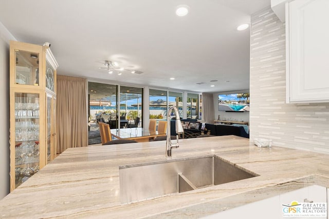 kitchen with tasteful backsplash, floor to ceiling windows, and sink