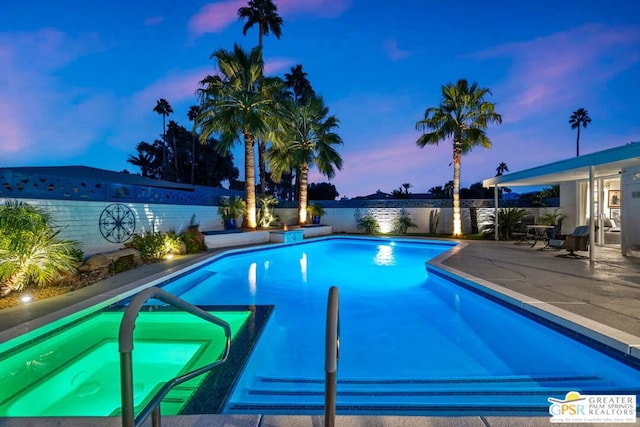 pool at dusk with a patio area