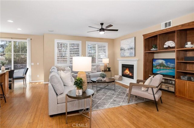 living room featuring ceiling fan and light hardwood / wood-style floors