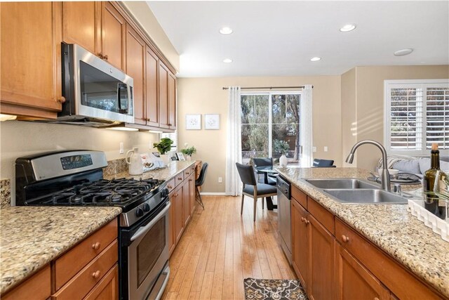 kitchen featuring sink, a wealth of natural light, appliances with stainless steel finishes, and light hardwood / wood-style flooring