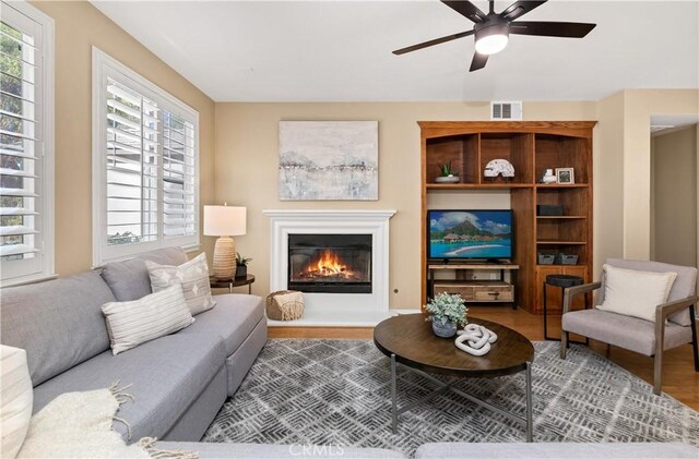 living room featuring ceiling fan and hardwood / wood-style floors