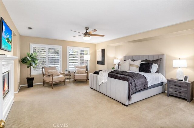 bedroom with ceiling fan and light carpet