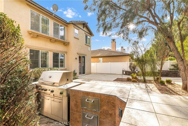 rear view of house featuring area for grilling and a patio