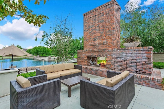 view of patio / terrace with a water view and an outdoor living space with a fireplace