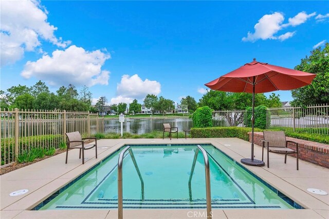 view of swimming pool with a water view and a patio