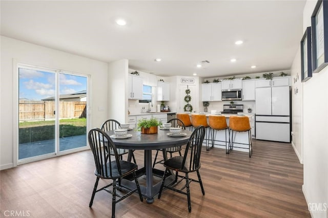 dining space with sink and wood-type flooring