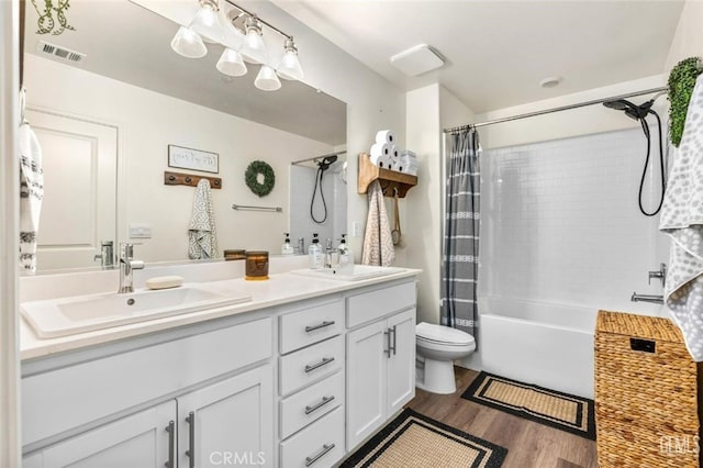 full bathroom featuring toilet, vanity, hardwood / wood-style floors, and shower / bath combo with shower curtain