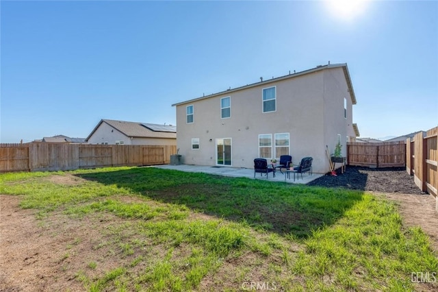 back of house featuring a lawn and a patio