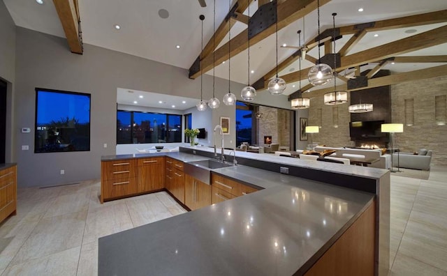 kitchen featuring beam ceiling, decorative light fixtures, and high vaulted ceiling