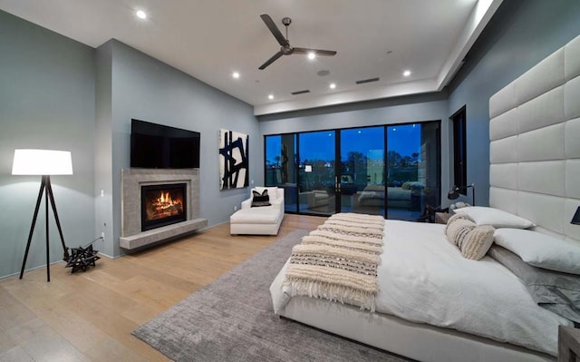 bedroom featuring ceiling fan, light hardwood / wood-style flooring, and access to exterior