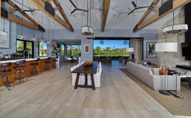 interior space featuring ceiling fan with notable chandelier, high vaulted ceiling, beamed ceiling, and sink