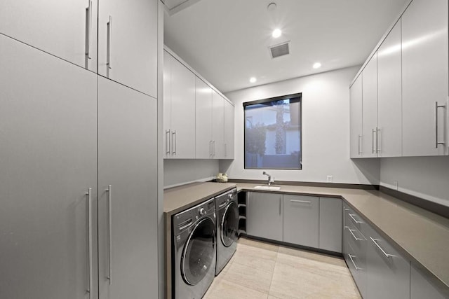 washroom featuring sink, cabinets, washer and clothes dryer, and light tile patterned floors