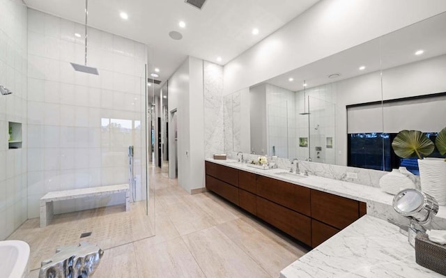 bathroom featuring tile walls, a tile shower, and vanity