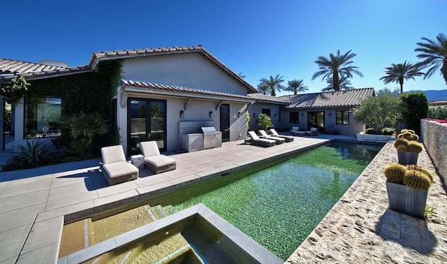 view of pool featuring a patio area, french doors, a hot tub, and area for grilling