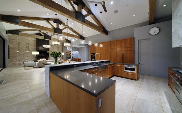 kitchen with hanging light fixtures, beamed ceiling, ceiling fan, high vaulted ceiling, and sink