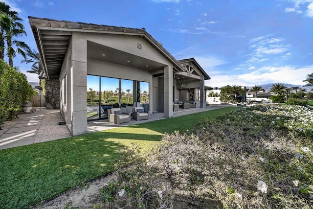 back of property with an outdoor hangout area, a patio area, and a yard