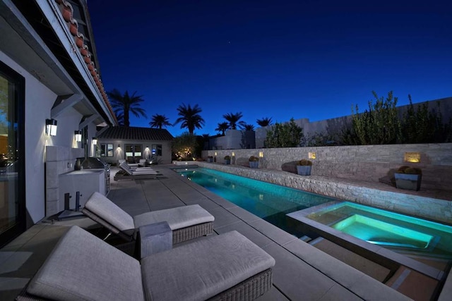 pool at twilight featuring an in ground hot tub, an outdoor structure, and a patio area