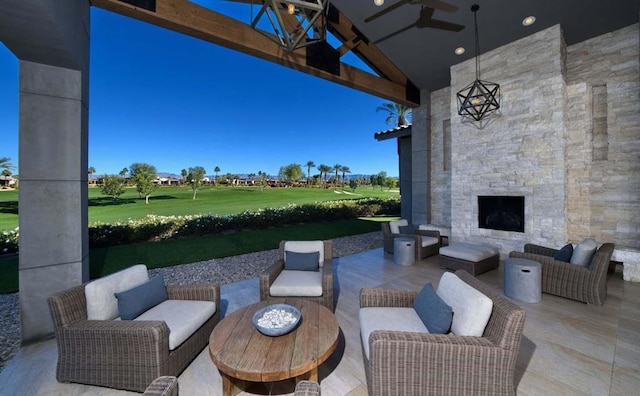 view of patio with ceiling fan and an outdoor living space with a fireplace