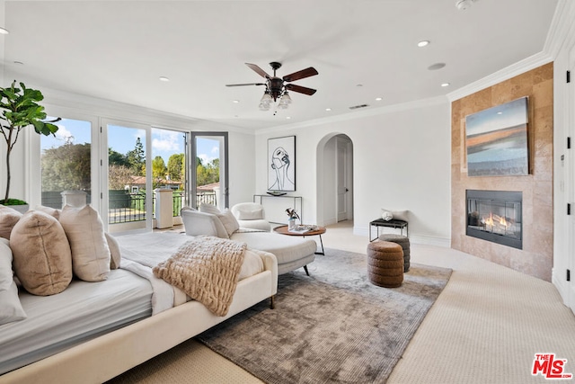 interior space featuring a fireplace, access to exterior, light carpet, ceiling fan, and crown molding