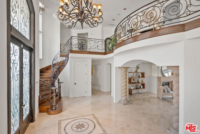 entryway featuring a high ceiling, french doors, an inviting chandelier, and crown molding