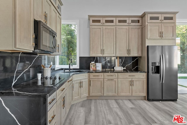 kitchen featuring light hardwood / wood-style flooring, light brown cabinetry, stainless steel fridge, tasteful backsplash, and sink