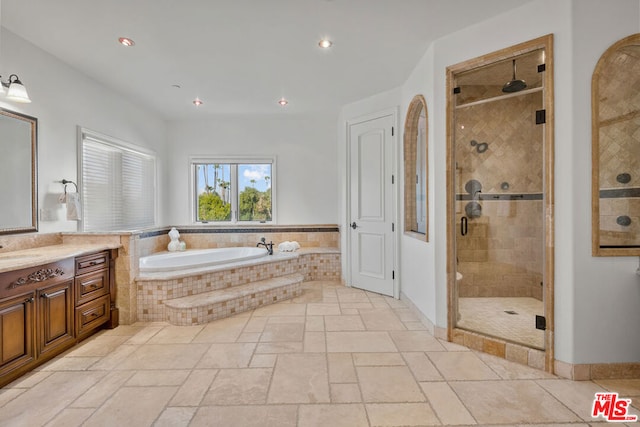 bathroom featuring shower with separate bathtub and vanity