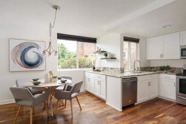 kitchen with sink, white cabinets, hanging light fixtures, and appliances with stainless steel finishes