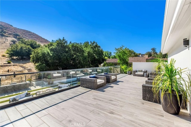 wooden terrace featuring a mountain view and an outdoor living space