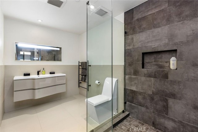 bathroom with vanity, tile patterned flooring, walk in shower, and tile walls