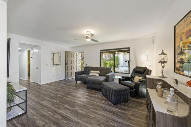 living room featuring ceiling fan and dark wood-type flooring